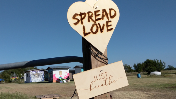 PLUR at Quasar Festival in Texas: "Just Breathe" message and heart-shaped sign with "Spread Love" 