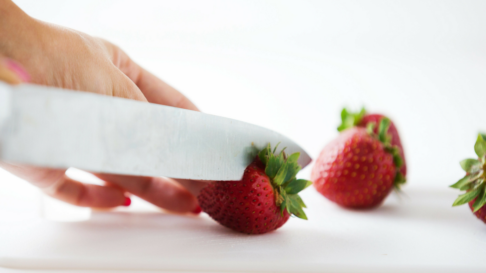 Slicing strawberries on a cutting board
