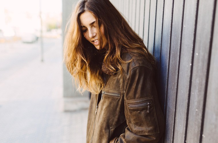 This Ancient Grain Could Seriously Strengthen Your Hair Article Image Of Girl Standing Against A Fence With Healthy Hair