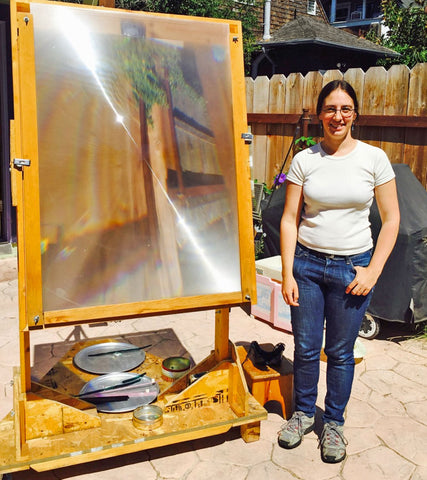 Tawny Reynolds next to the giant magnifying glass she uses to focus sunshine and create Sundrop Jewelry