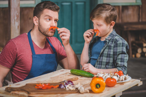 A father and son cutting vegetables and cooking food