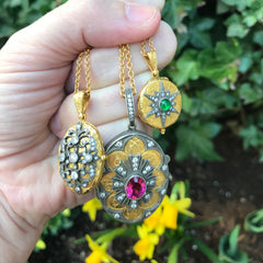 Arman 22k and silver handmade lockets being held in a hand