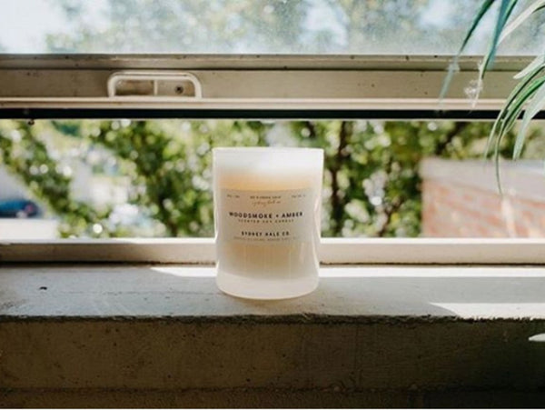 Sydney Hale candle sitting on a window sill on a sunny summer day