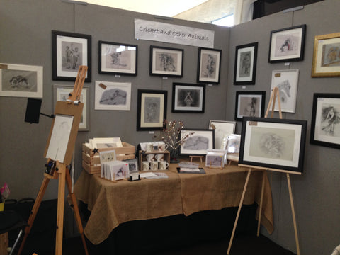 art fair stall exhibiting cricket and animal original drawings and prints with cricket mugs and cricket cards