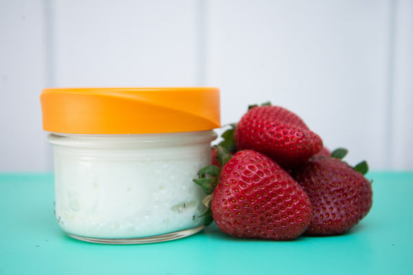 reusable iLid on a mason jar full of yogurt beside fresh strawberries