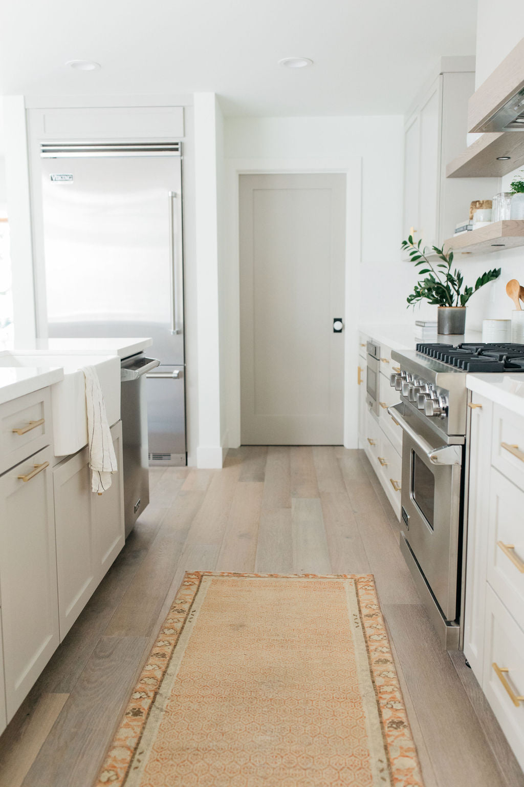 greige design shop + interiors alexandria project light grey cabinetry brass hardware vintage rug runner