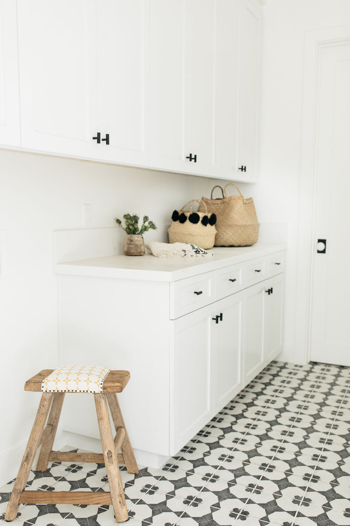greige design shop + interiors albion project san diego california white cabinets laundry room black and white tile floors