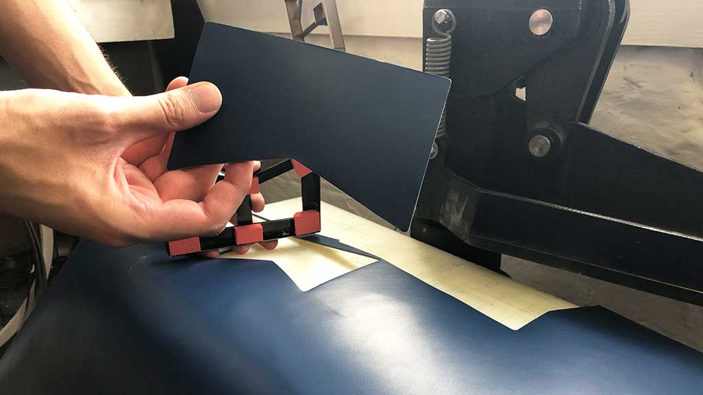 Leather lined up on press to be cut