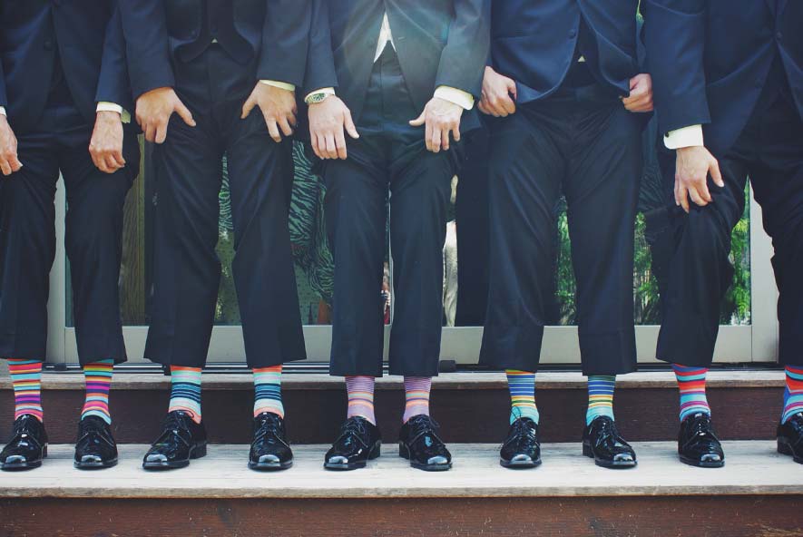 Men, wearing suits with multicoloured socks
