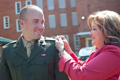 Mom pinning rank on soldier
