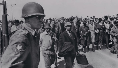 National guardsman watching demonstrators marching in the civil rights era