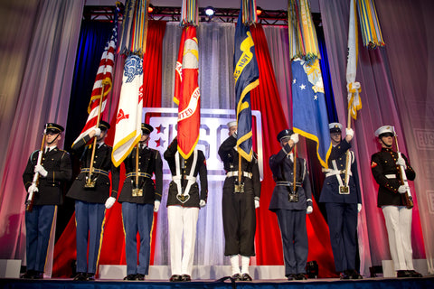 Soldiers of every branch of the US military in full dress bearing flags
