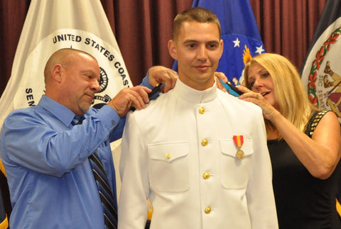 USCG recruit having rank pinned on by his parents