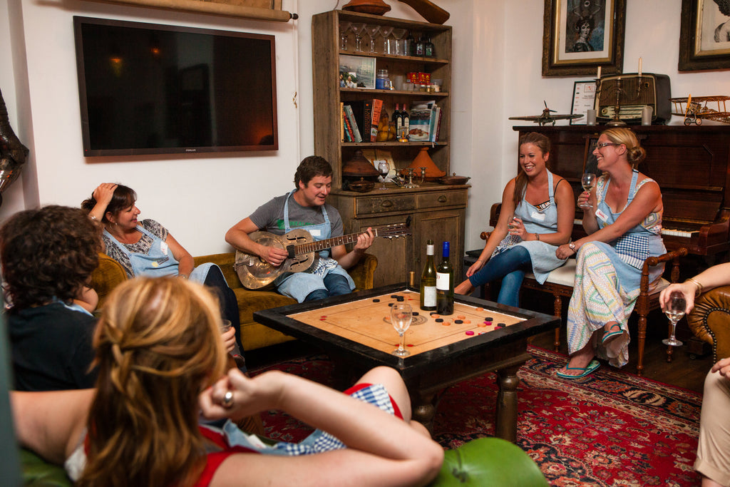 Food at 52 cookery school wins most home away from home, image from living room of guests having a relaxed time with a guitar and wine.