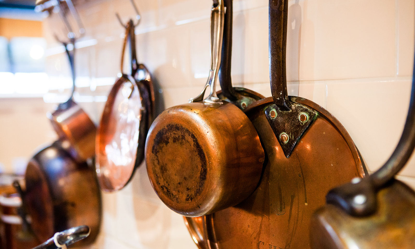 Copper cookware completes the cottage kitchen effect.