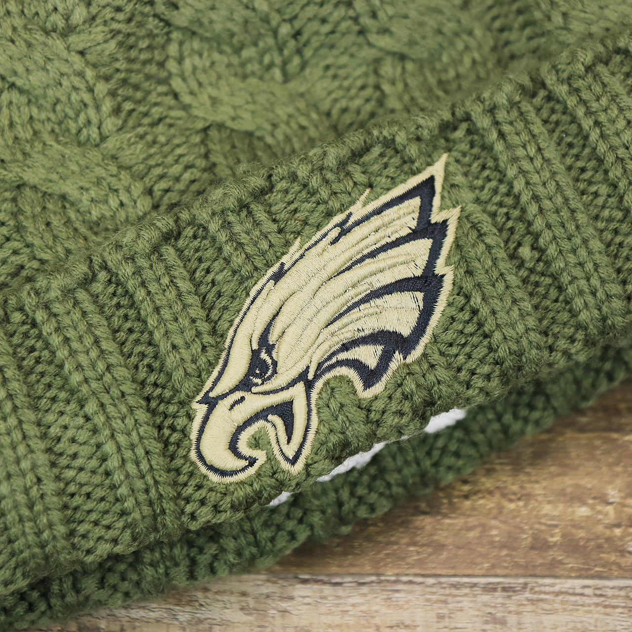 The Eagles Logo on the Women’s Philadelphia Eagles Stars And Stripes Patch Salute To Service Ribbon NFL On Field Beanie | Women’s Olive Green Beanie