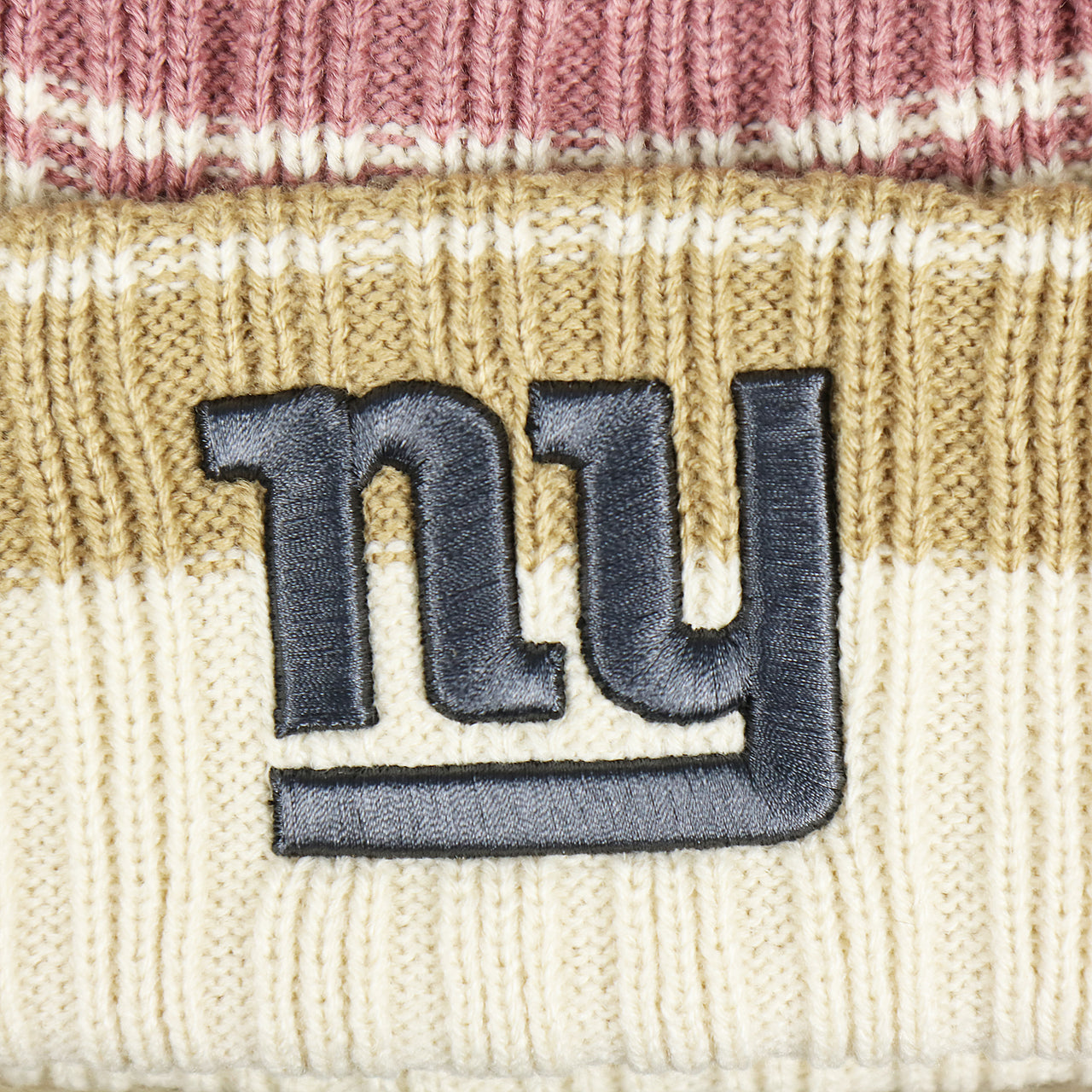 The Giants Logo on the Women’s New York Giants Black Giants Logo Pom Pom Beanie | Women’s Natural Beanie