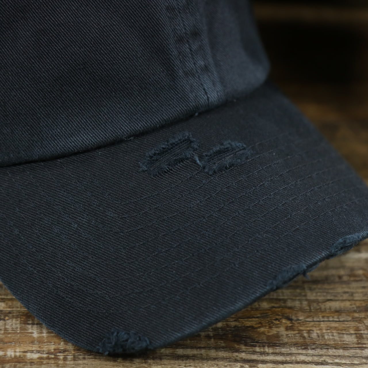 The Visor on the Jet Black Bent Brim Blank Distressed Baseball Hat | Black Dad Hat