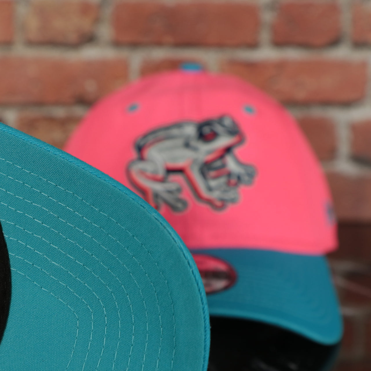 blue under visor on the Lehigh Valley Ironpigs Coqui Copa De La Diversion 2023 Two-Tone Black Bottom 9Twenty Dad Hat | Pink/Blue 920