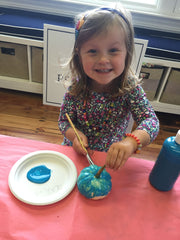 Scarlett smiling while she paints.