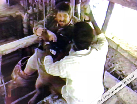 Srin Lankan miner tries to get Robert Lewis Knecht to let go of a rope while hanging over a 120 foot deep blue moonstone mine shaft