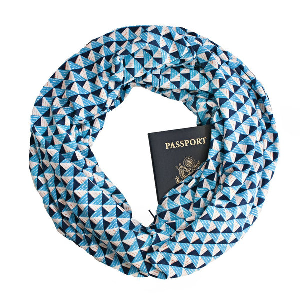 A rayon jersey travel scarf with a hidden zippered pocket that haas blue geo print.