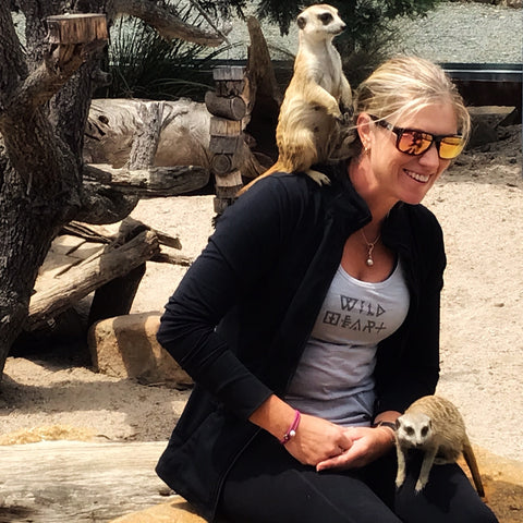 woman with meerkat sitting on her