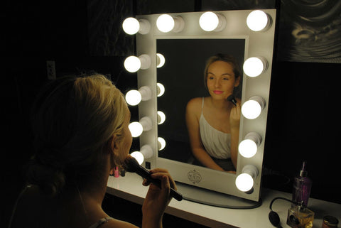 Woman Doing Makeup in Mirror with LED Lights