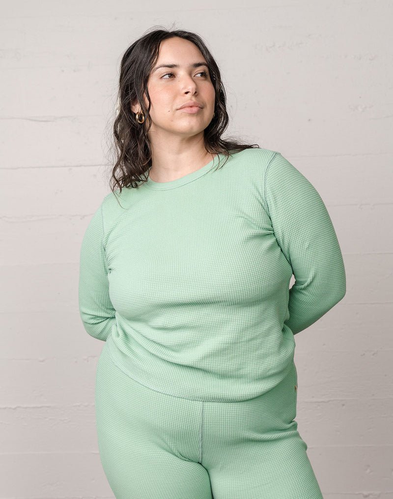 Woman wearing an organic waffle thermal top in sage.