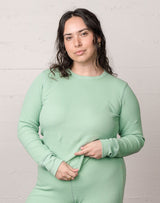 Woman wearing an organic waffle thermal top in sage.