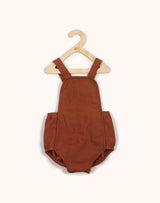 Noble Sun Suit in Cinnamon color hanging from a kids hangar