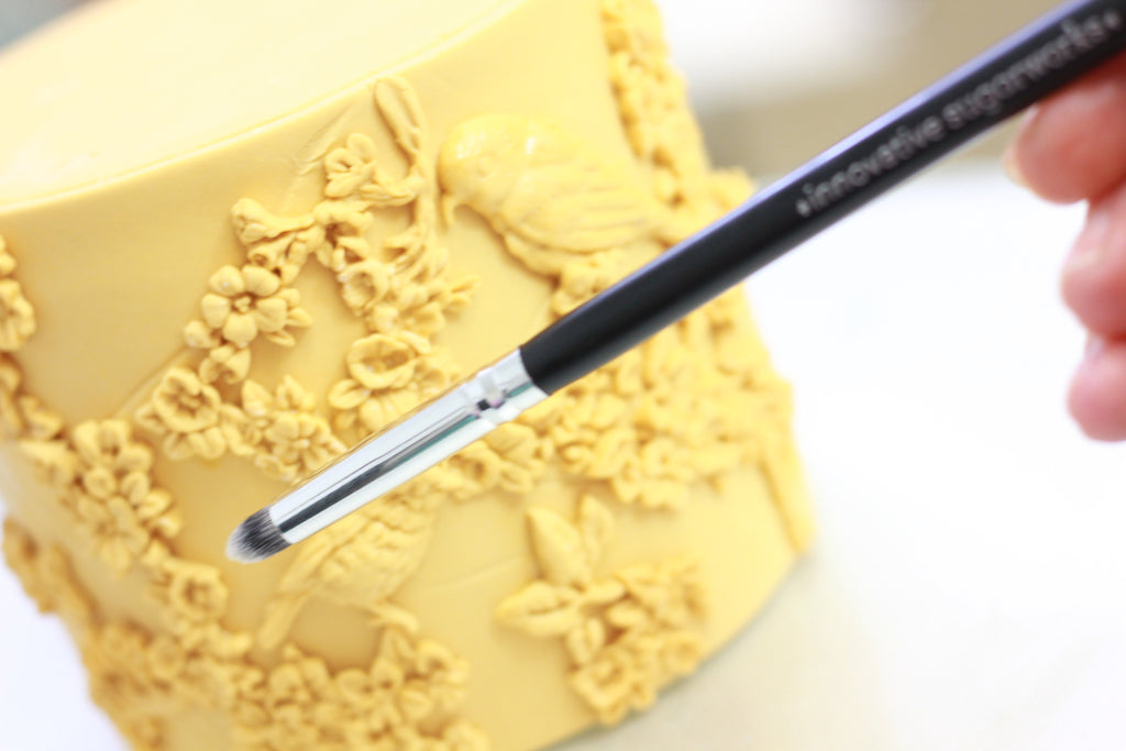 Using Innovative Sugarworks Artists' Brushes to apply molded fondant to cake