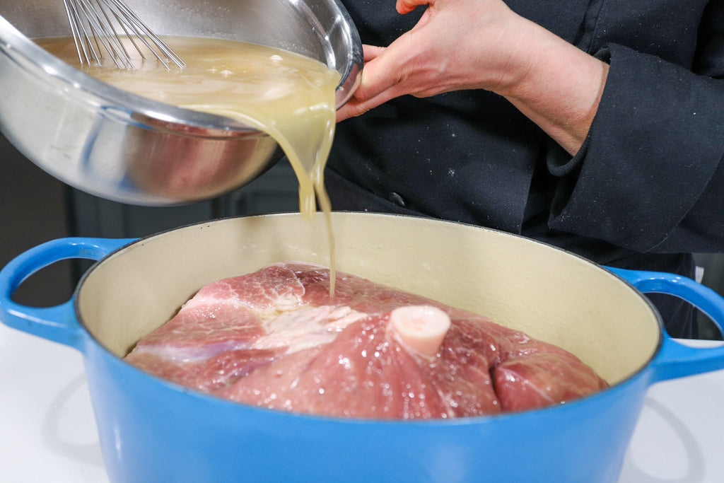 ham cure being poured on the fresh ham