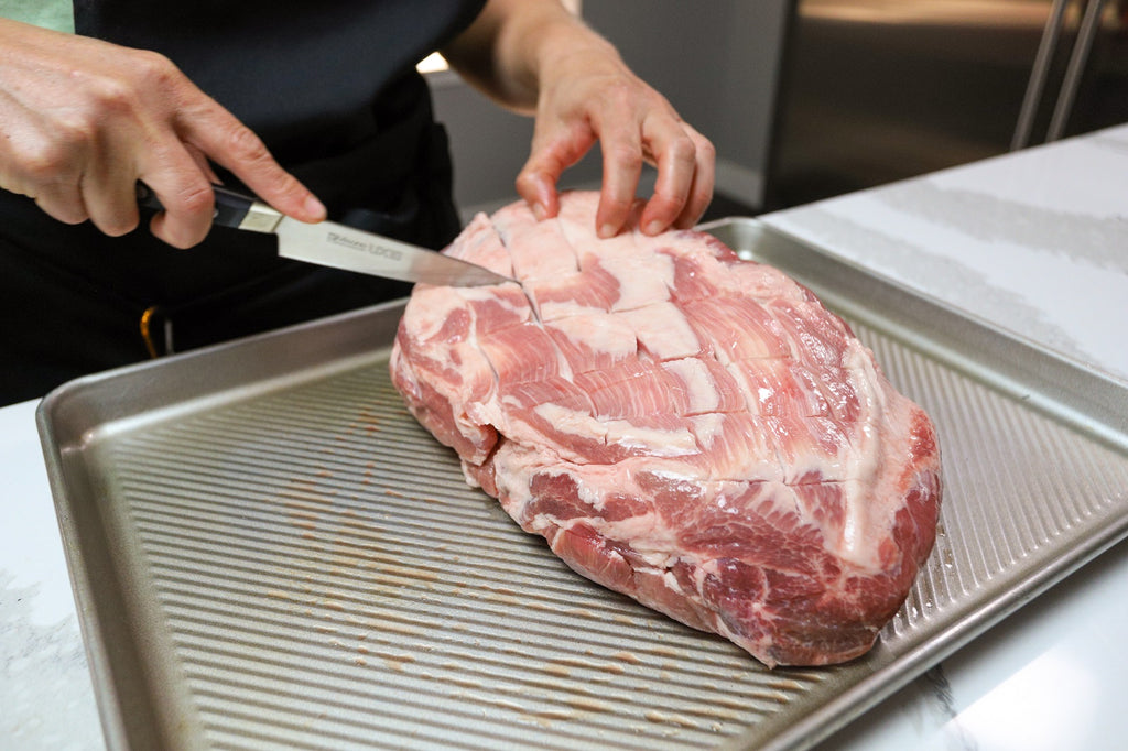 piece of pork being cut and prepared for hawaiian smoked pork