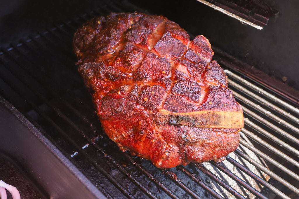 pork shoulder cooking on the barbecue grill and being smoked