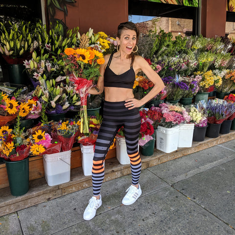 Tandy smiles with flowers in hand in front of a flower shop.