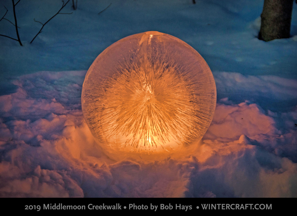 An extra large globe ice lantern with stunning lines radiating throughout found along the walking path by Bob Hays and his camera.