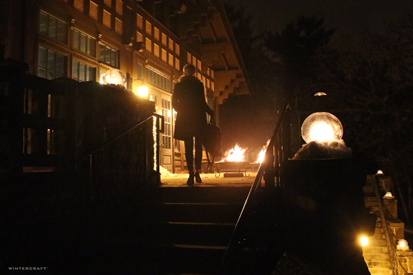Lady entering Chalet with lit with Globe Ice Lanterns Wintercraft