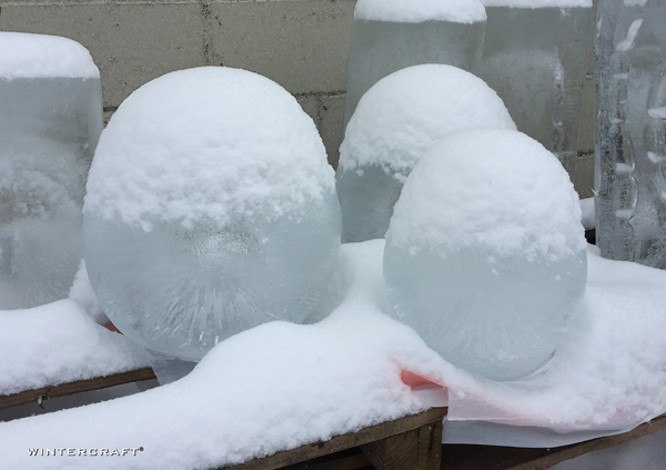 Wintercraft Globe Ice Lanterns waiting to work under a blanket of snow