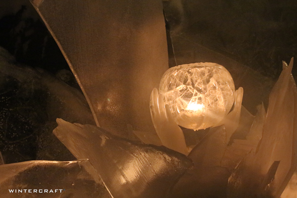 Ice hands hold a candlelit globe in an ice glass display at a Middlemoon Creekwalk
