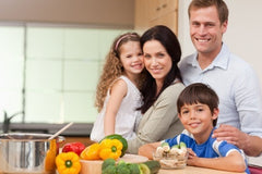 Smiling family standing in the kitchen together