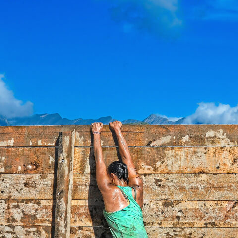 Woman climbing a wall and perspiring