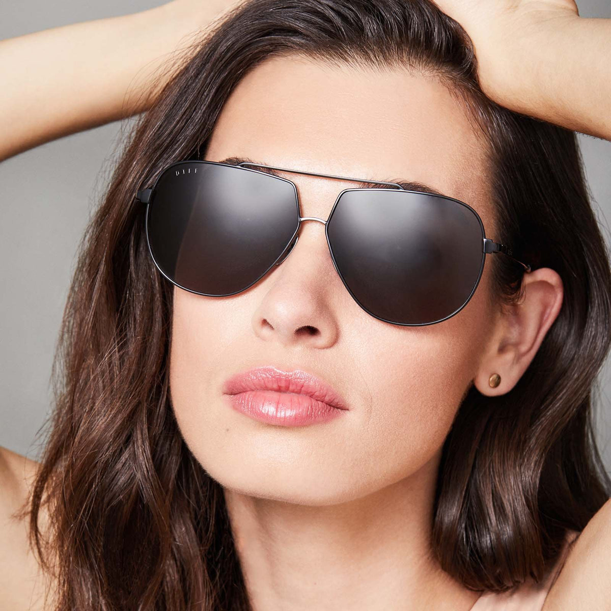 Sunglasses with black frames and grey polarized lens on a female model