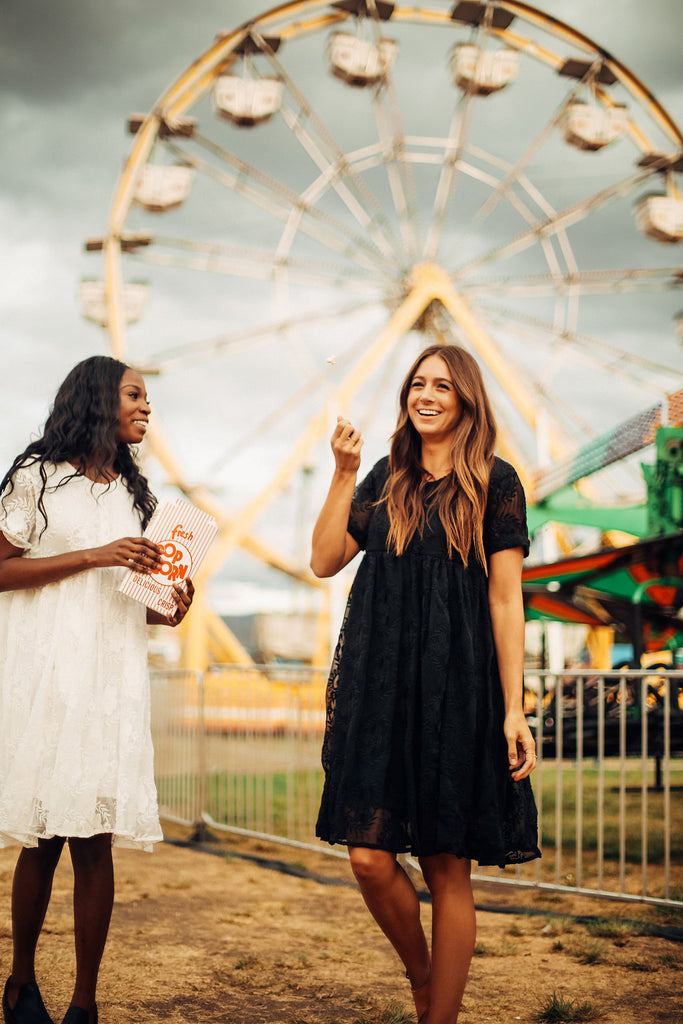 A piper & scoot model showing off the Ellie dress in black at a carnival