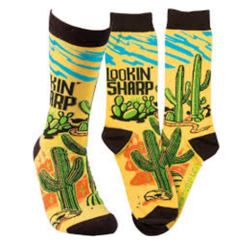 Get yourself looking sharp with these yellow socks with black toe, heel, and top. green cacti print images with an orange desert background and wavy blue streaks by the top.