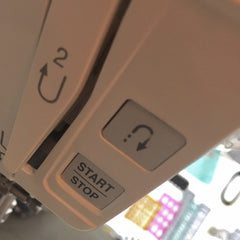 backstitch button on a sewing machine