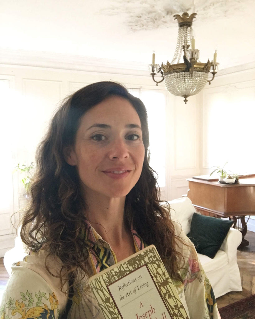 Hrissa Soumpassis in Paris apartment with chandelier and book.