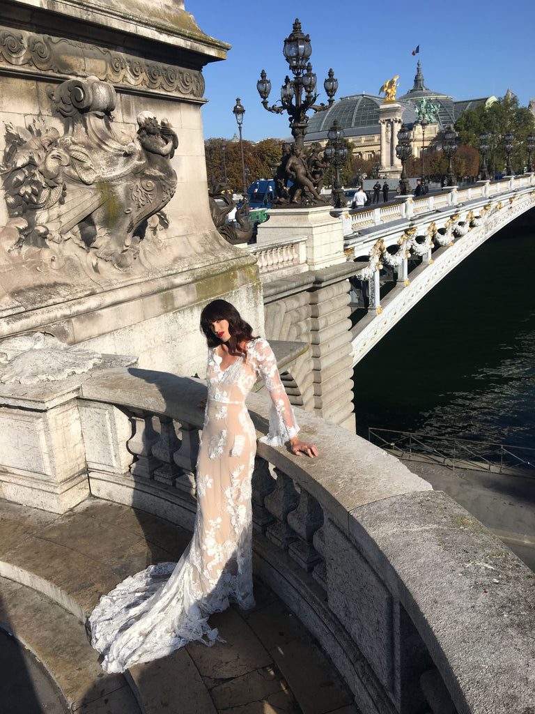 model posing on a bridge in Paris in a wedding dress.