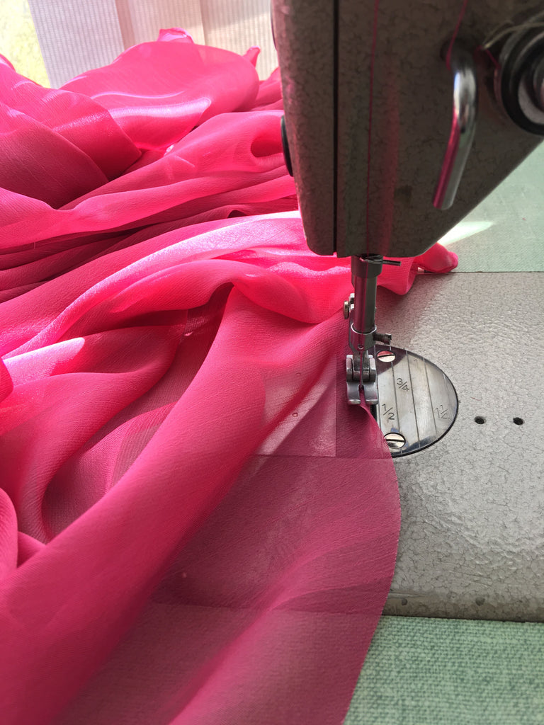 Sewing machine sewing chiffon of custom wedding dress in pink for Elika In Love's Vancouver bride.