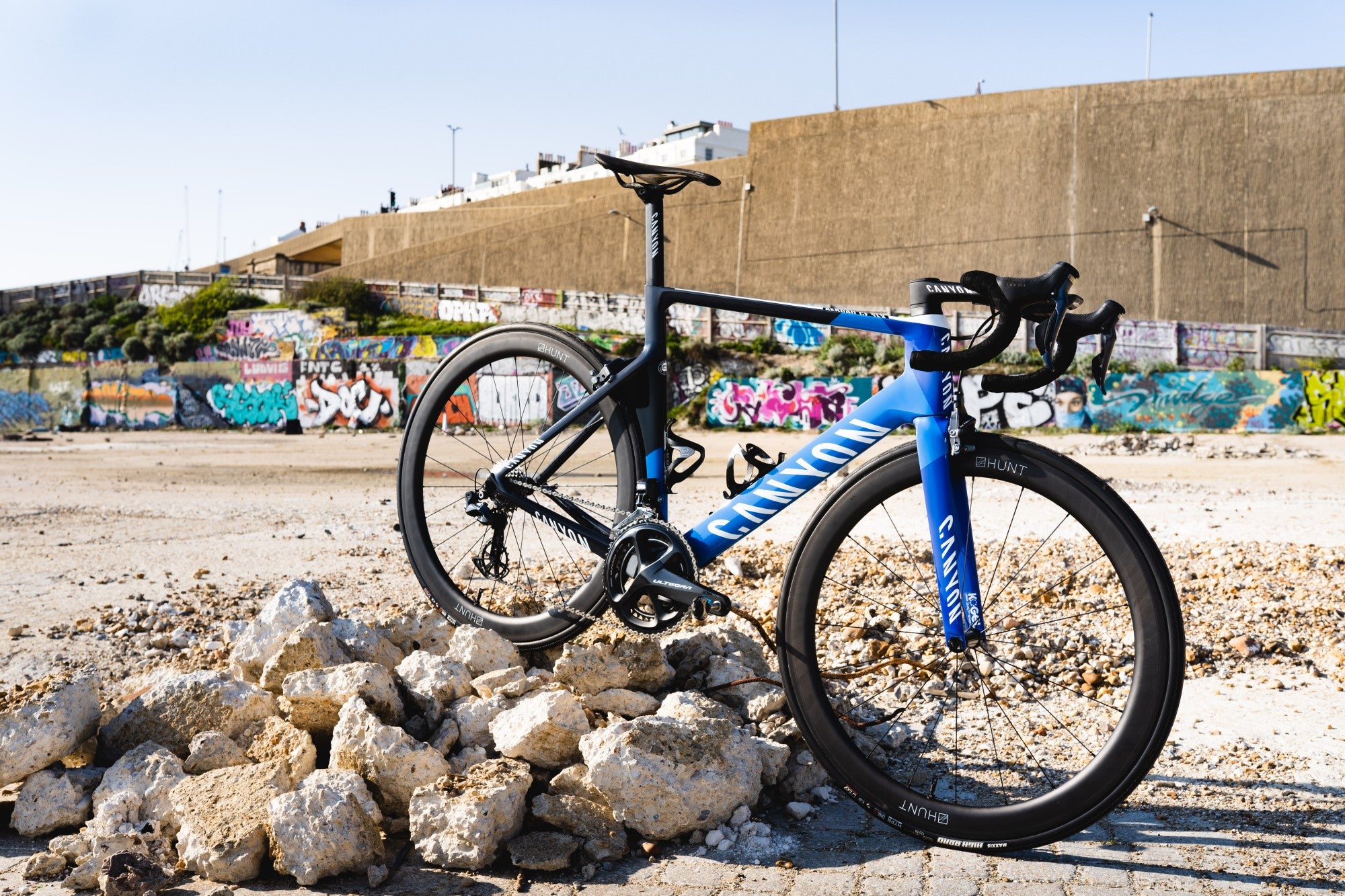 The Canyon Aeroad with HUNT 50 Carbon Wide Aero Wheels propped up on a beach